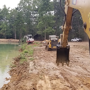 Skid Steers and small cranes constructing a pond